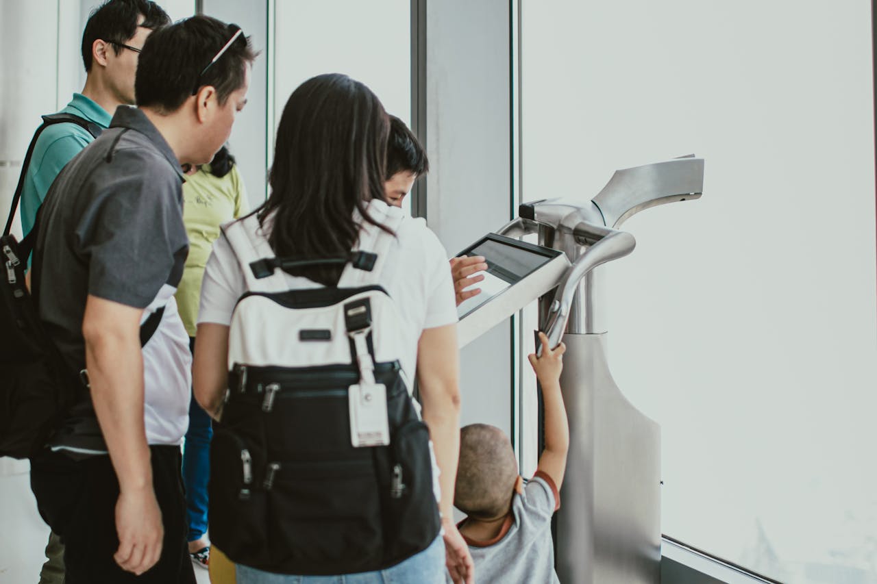 Family using digital telescope at observation deck in Dubai, UAE.