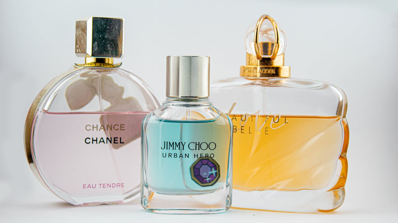 about-img Elegant display of designer perfume bottles featuring Chanel, Jimmy Choo, and Estee Lauder.